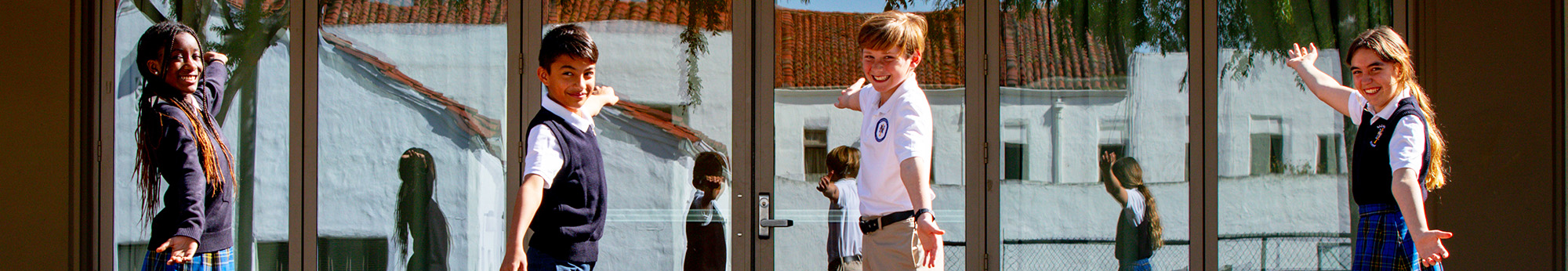 Four happy students welcoming you to Nazareth School