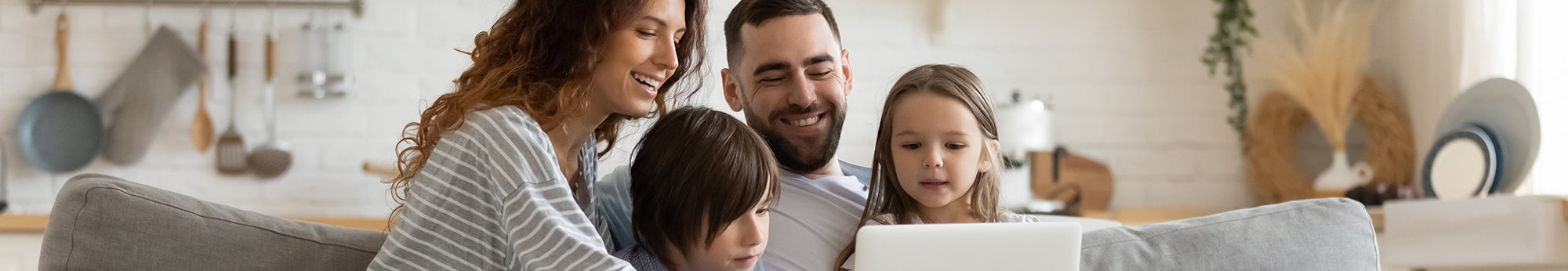 mom, dad, and two kids gathered around a laptop