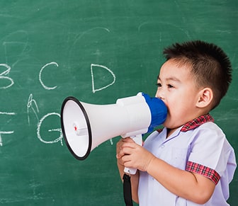 boy in front of chalkboard with megaphone