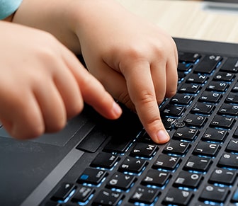 kid hands typing on a laptop