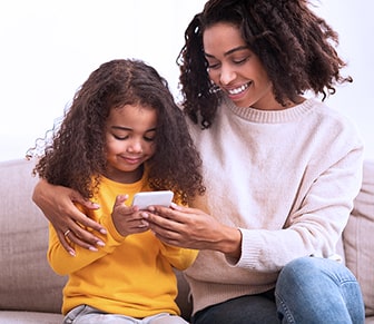 mother and daughter looking at a smartphone together