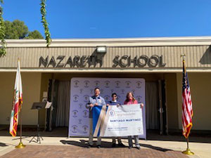 Santiago Martinez holding his check for the Merit Scholarship