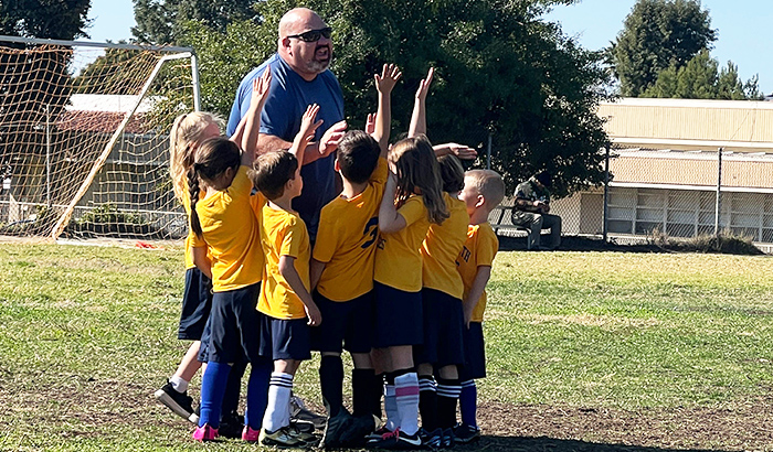 Soccer team huddle with coach