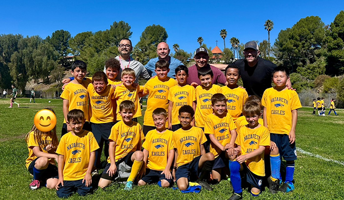 Nazareth Eagles athletic team dressed in yellow uniforms and their coaches