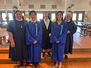 Grace Balkowski and Mason Bautista in graduation gown with Sisters