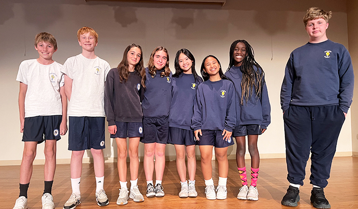 Group of happy students on stage helping with Willy Wonka Jr.