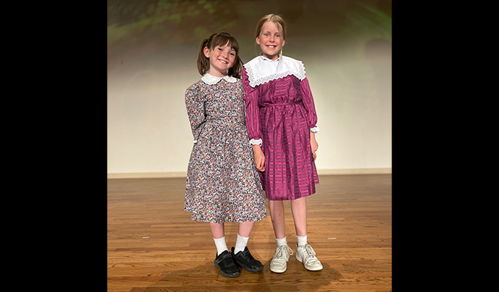 Two girls in dresses on stage
