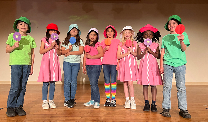 Group of student actors on stage and in colorful costumes