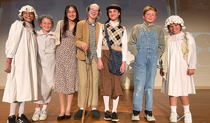 Group of students actors posing for a picture on stage