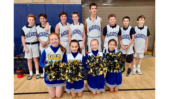 Cheerleaders posing with basketball team