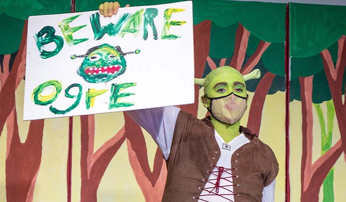 Student as Shrek holding Beware of Ogre sign